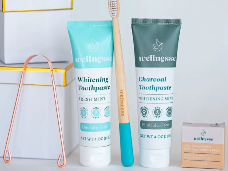 Natural toothpaste set with charcoal and mint options, bamboo toothbrush, floss, and copper tongue scraper.