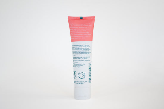 Strawberry fluoride free toothpaste for sensitive teeth with hydroxyapatite and soothing aloe, showing ingredients and benefits on tube back