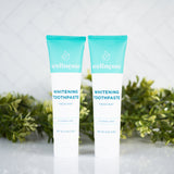 All natural whitening toothpaste tubes from Wellnesse, featuring fresh mint flavor and fluoride-free formula with green foliage background.
