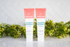 Strawberry healthy toothpaste without fluoride in two tubes displayed with green plants on a clean bathroom counter.