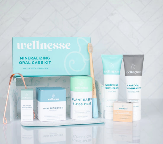 Dental clean kit by Wellnesse featuring toothpaste, floss picks, probiotics, copper tongue scraper, and bamboo toothbrush for oral health