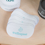 Mouth tape and containers on a wooden surface with 'wellness' branding.