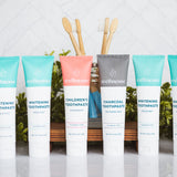 Natural chemical free toothpaste collection featuring whitening mint, charcoal, and children's strawberry flavors with eco-friendly bamboo toothbrushes