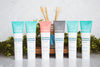 Organic hydroxyapatite toothpaste lineup including whitening mint, charcoal, and children's strawberry flavors with bamboo toothbrushes in a glass jar