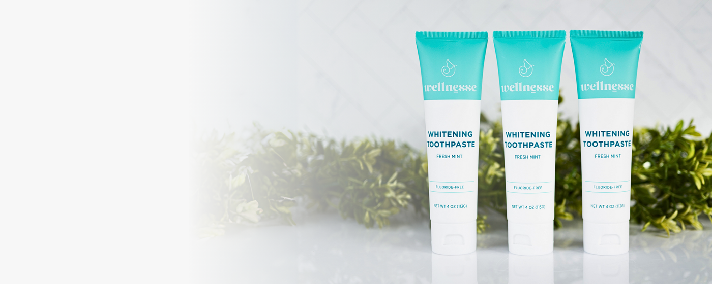 Fluoride-free mint whitening toothpaste trio from Wellnesse, displayed with fresh greenery and clean white background.