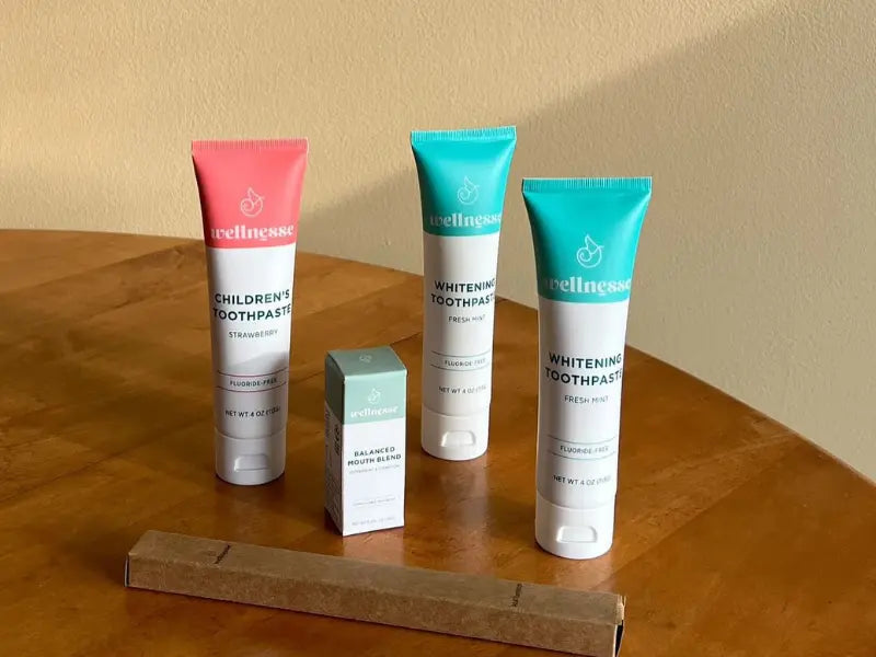Natural oral health remedies Wellnesse toothpaste and mouth blend set arranged on a wooden table for holistic dental care