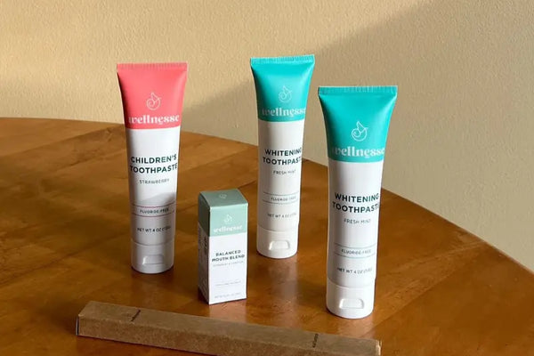 Natural oral health remedies Wellnesse toothpaste and mouth blend set arranged on a wooden table for holistic dental care
