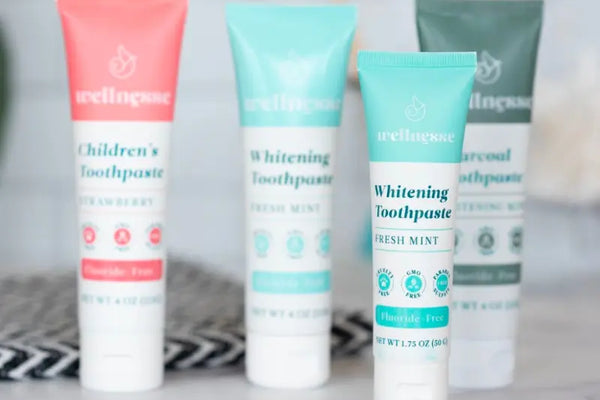 Natural oral care products including fluoride-free toothpaste in fresh mint, charcoal, and strawberry varieties.
