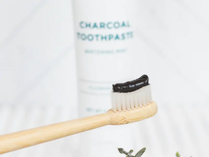 Natural whitening toothpaste shown on a bamboo brush for gentle brightening