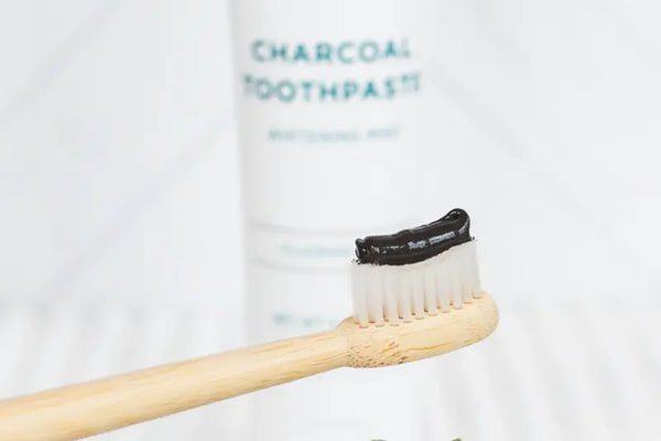 Natural whitening toothpaste shown on a bamboo brush for gentle brightening