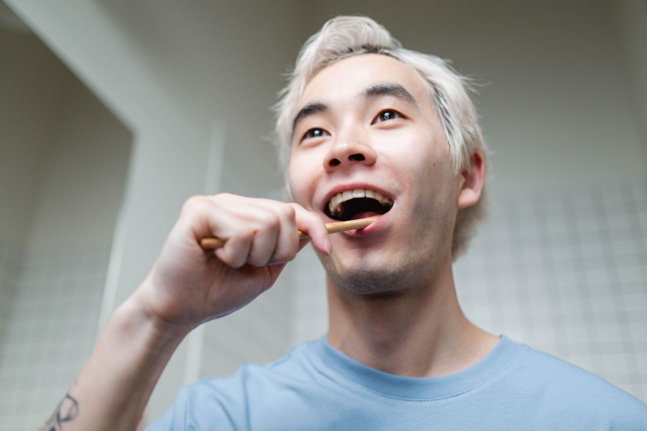 A man brushing his teeth in a bathroom.