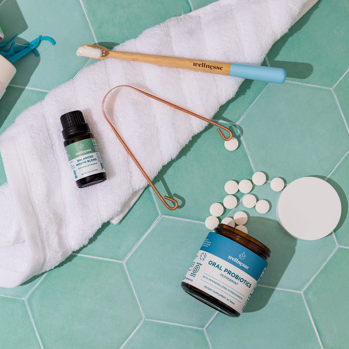 Wellnesse oral probiotic mints in peppermint beside fresh mint leaves on a clean surface