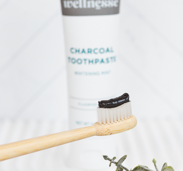 Wellnesse charcoal toothpaste tube on a clean white background showing the whitening mint label