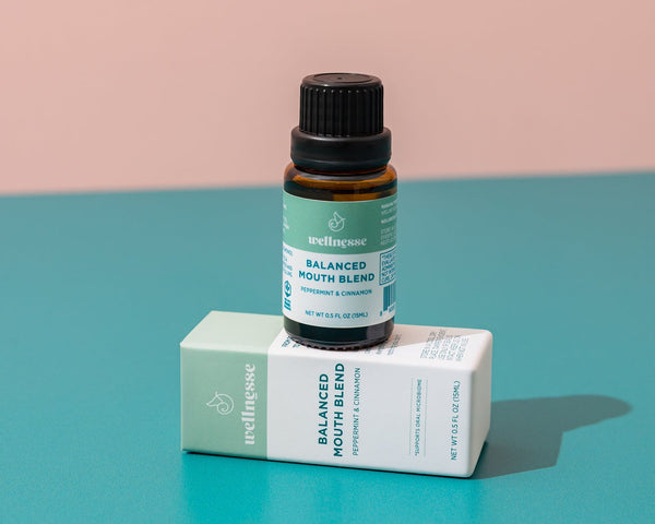 Close-up of Wellnesse non toxic mouthwash dropper bottle next to the branded packaging box