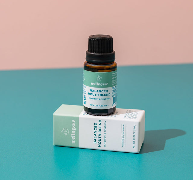 Close-up of Wellnesse non toxic mouthwash dropper bottle next to the branded packaging box