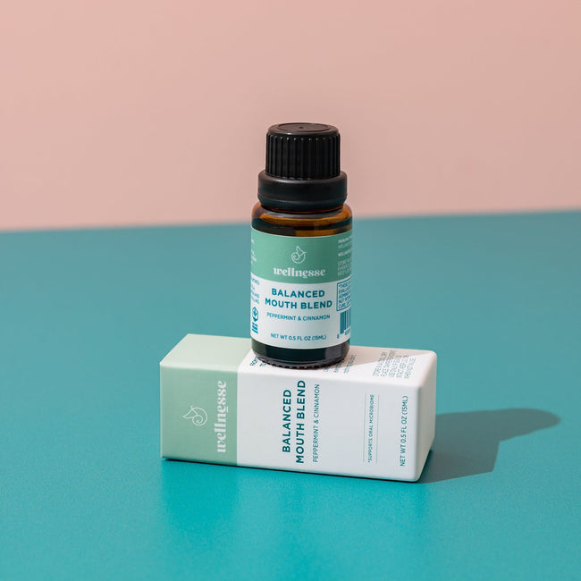 Close-up of Wellnesse non toxic mouthwash dropper bottle next to the branded packaging box