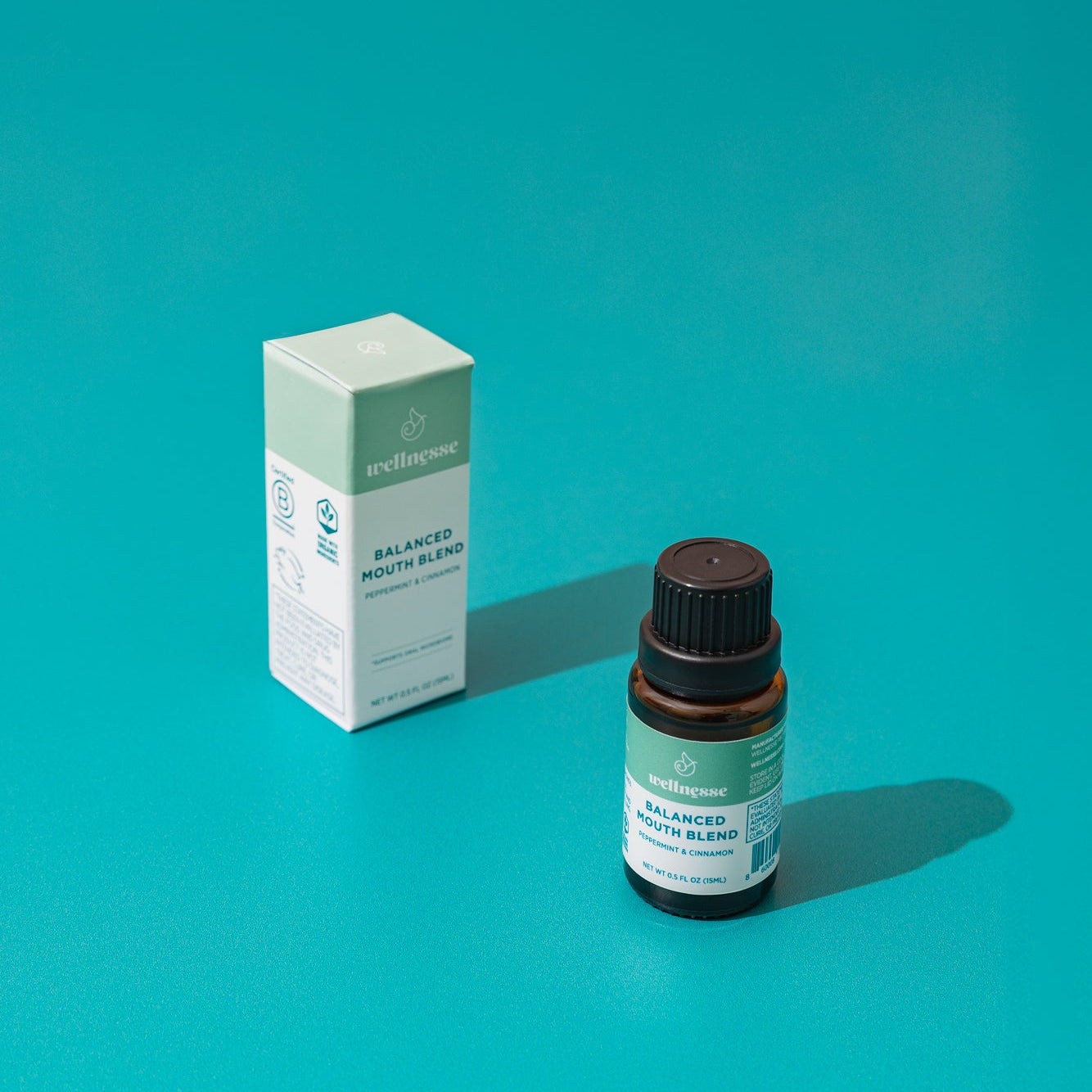 Wellnesse non toxic mouthwash styled with oral care products on a natural wood surface