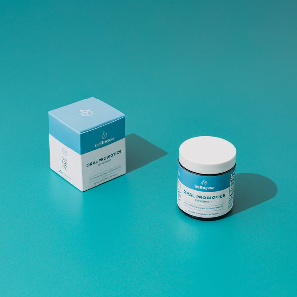 Wellnesse oral probiotic mints scattered beside the open jar showing the dissolvable tablet shape