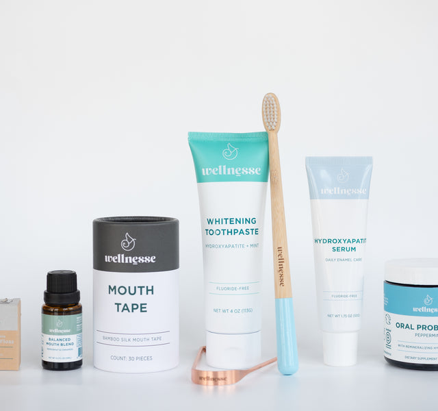 Wellnesse oral care essentials featuring mouth tape, toothpaste, hydroxyapatite serum, and a bamboo toothbrush.