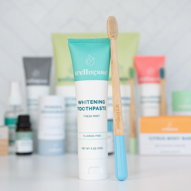 Best natural whitening toothpaste from Wellnesse in a fresh mint fluoride-free formula, shown with a bamboo toothbrush and full oral care lineup.