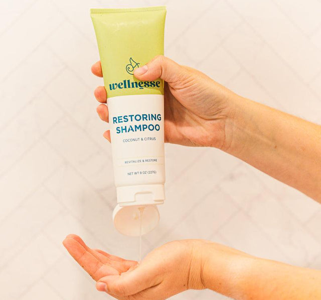 Wellnesse restoring shampoo and conditioner bottles together in a styled lifestyle flat lay