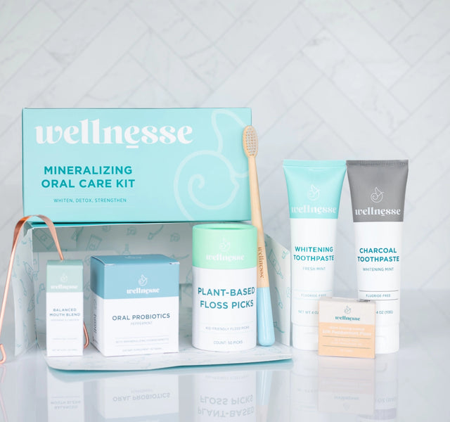 Wellnesse oral care kit featuring toothpaste, floss picks, probiotics, copper tongue scraper, and toothbrush