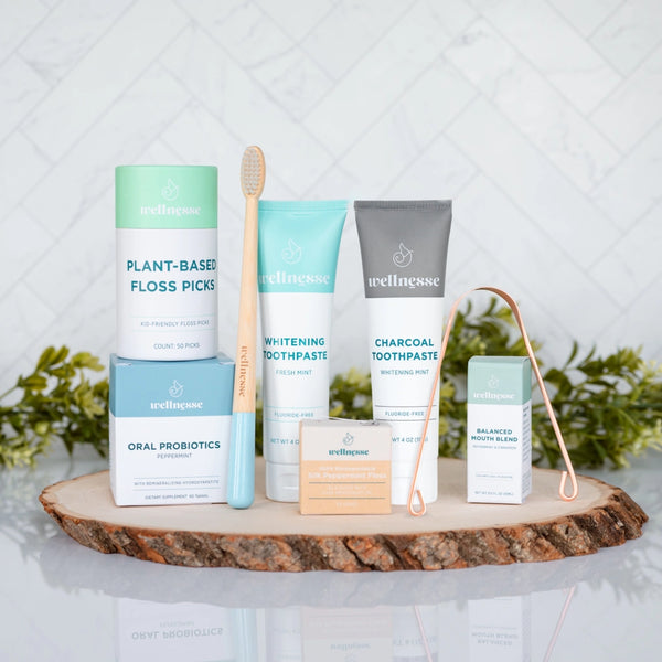 Complete Wellnesse oral care kit spread showing all products including toothpaste, floss, and mouth blend
