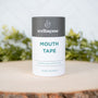 Wellnesse mouth tape container on a wooden surface with a blurred green background