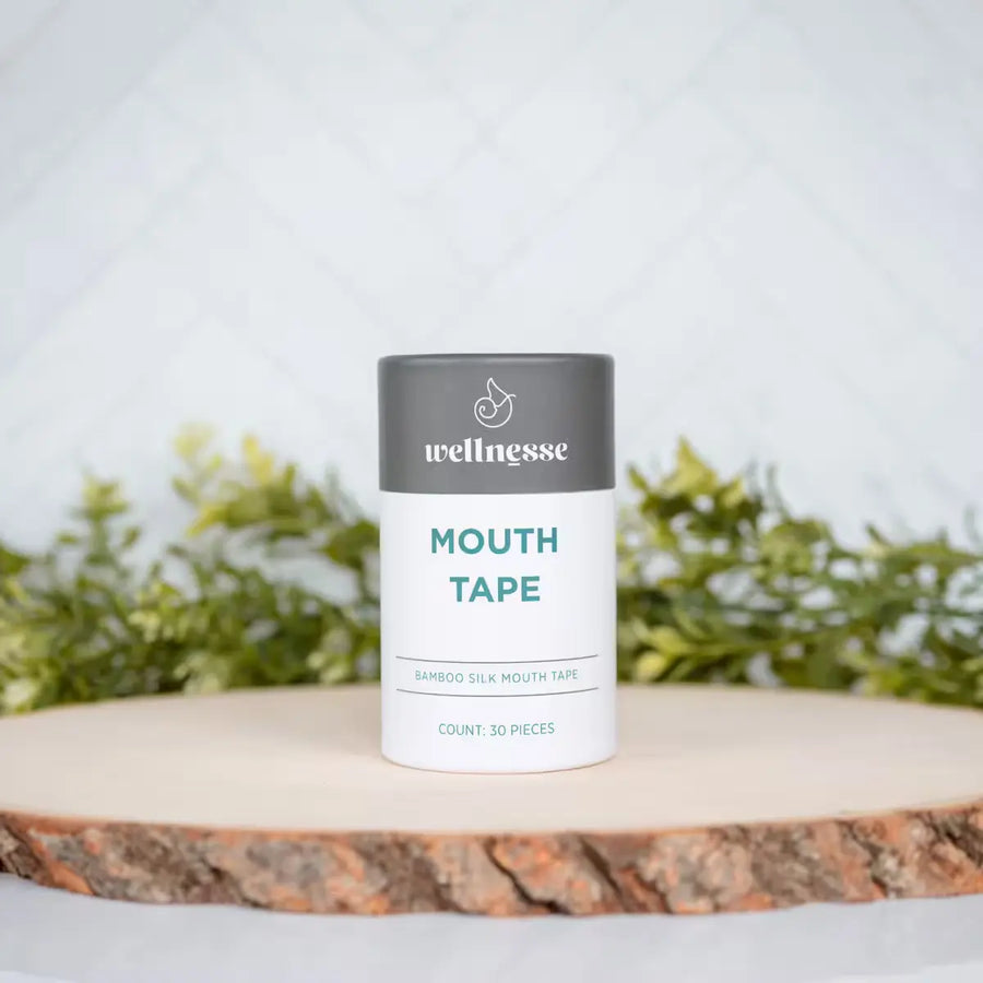 Wellnesse non toxic mouth tape 30-piece bamboo silk container on a natural wood slice with greenery