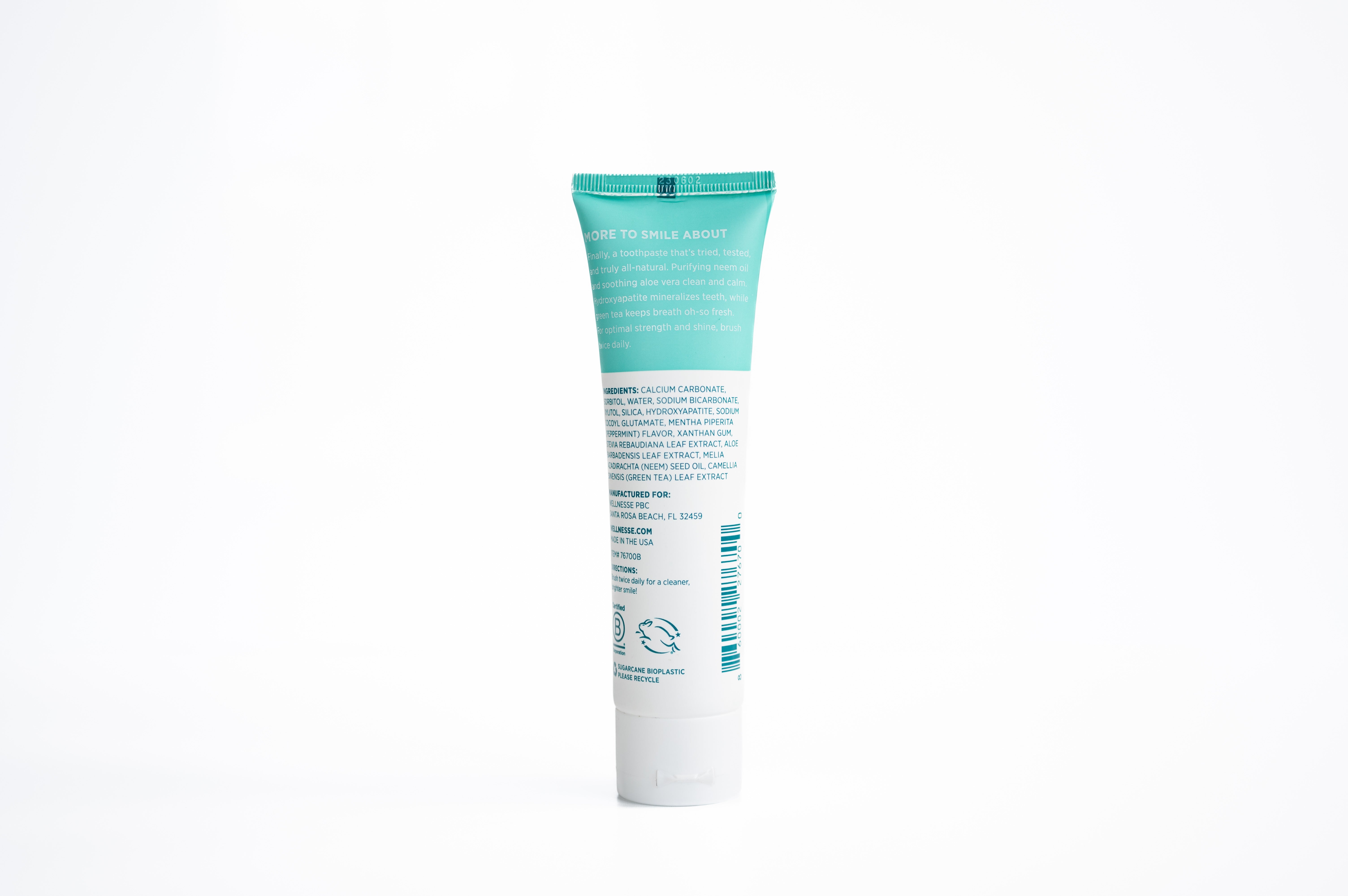 Fluoride free toothpaste for sensitive teeth with hydroxyapatite and soothing aloe, shown with ingredient list on mint-green Wellnesse tube.