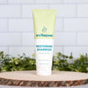 Restoring shampoo by Wellnesse in a coconut and citrus formula, displayed upright on a wood slice with greenery.