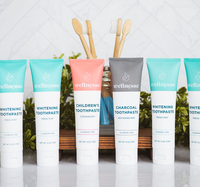 Natural chemical free toothpaste collection featuring whitening mint, charcoal, and children's strawberry flavors with eco-friendly bamboo toothbrushes