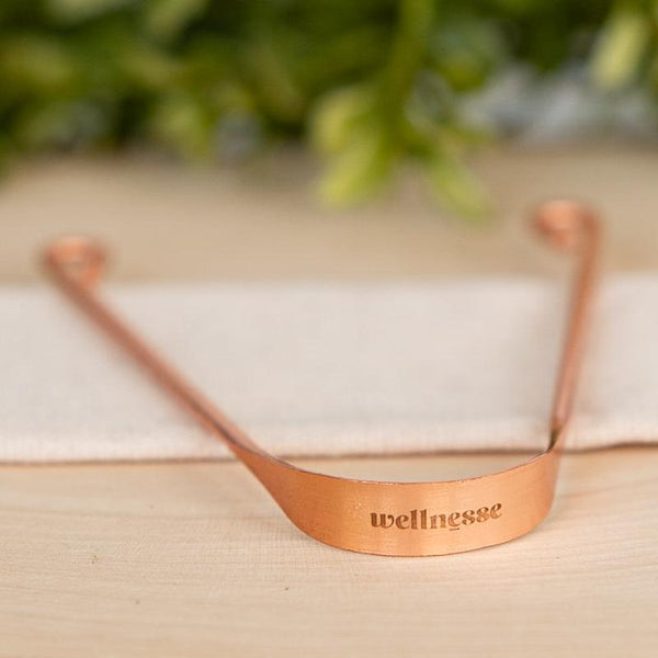 Close-up of Wellnesse copper tongue scraper detail showing the smooth antimicrobial scraping edge