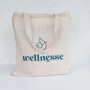 Wellnesse branded beige canvas tote bag with teal logo and lettering on a white background.