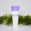 Tube of Wellnesse Vanilla Berry toothpaste on a white surface with greenery in the background