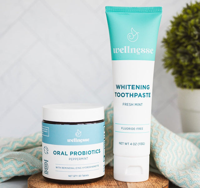 Wellnesse remineralizing toothpaste tube next to the oral probiotic mints jar in a styled shot