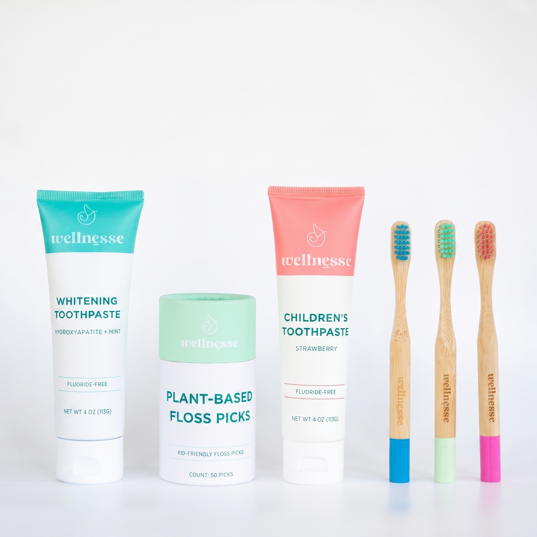 Wellnesse children's oral care products with toothpaste, plant-based floss picks, and bamboo toothbrushes.
