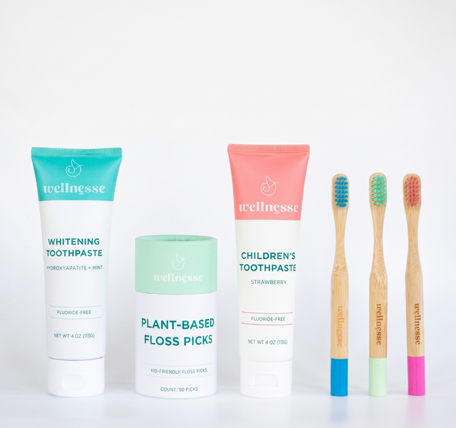 Wellnesse children's oral care products with toothpaste, plant-based floss picks, and bamboo toothbrushes.