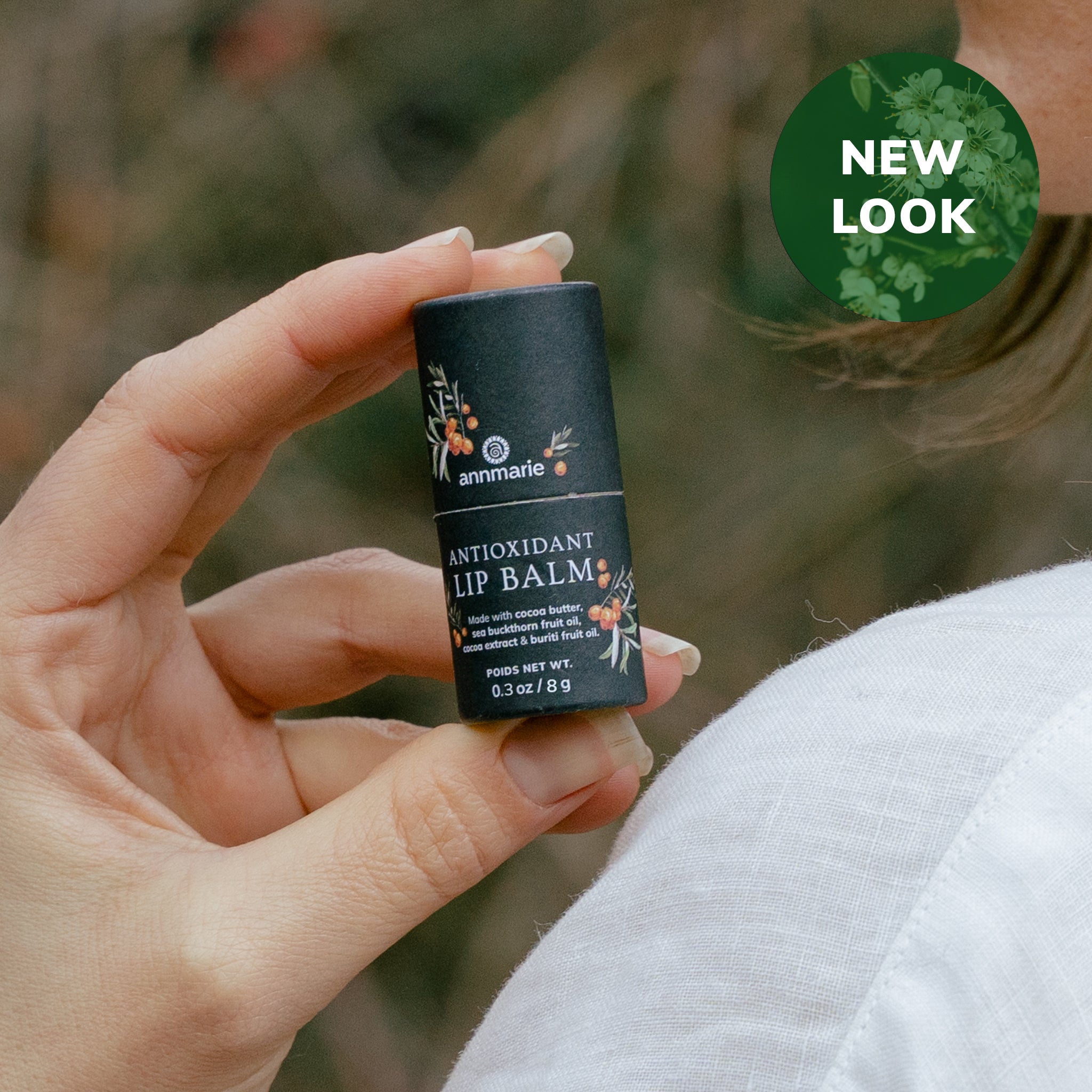 Antioxidant Lip Balm held in hand outdoors with a new-look badge and soft natural background