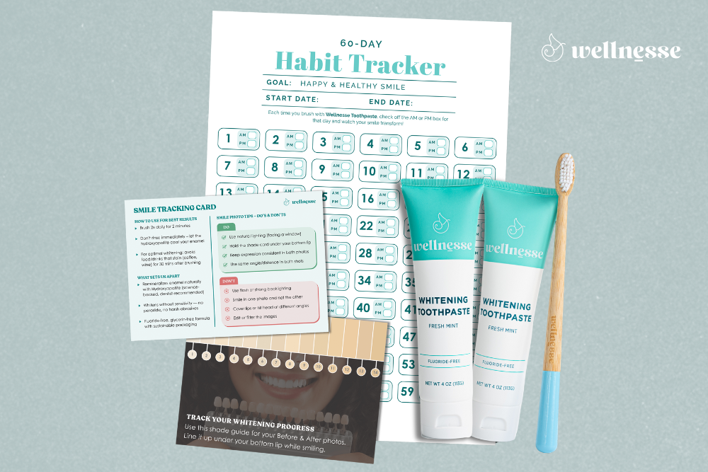 Whitening mint toothpaste by Wellnesse shown with a bamboo toothbrush, habit tracker, and smile shade guide.
