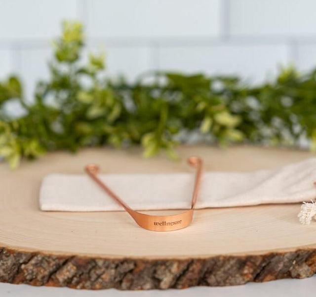 Wellnesse copper tongue scraper with an antimicrobial U-shaped design and engraved logo