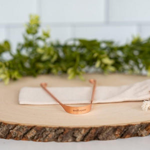 Wellnesse copper tongue scraper with an antimicrobial U-shaped design and engraved logo