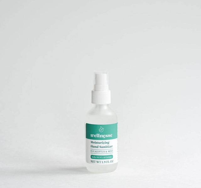 Wellnesse hydrating hand sanitizer being pumped onto hands in a lifestyle setting