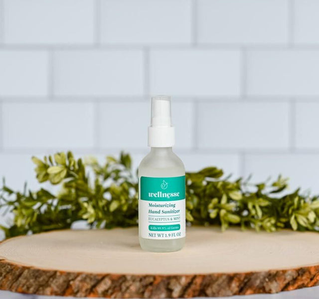Wellnesse moisturizing hand sanitizer in a recyclable glass bottle with eucalyptus and tea tree