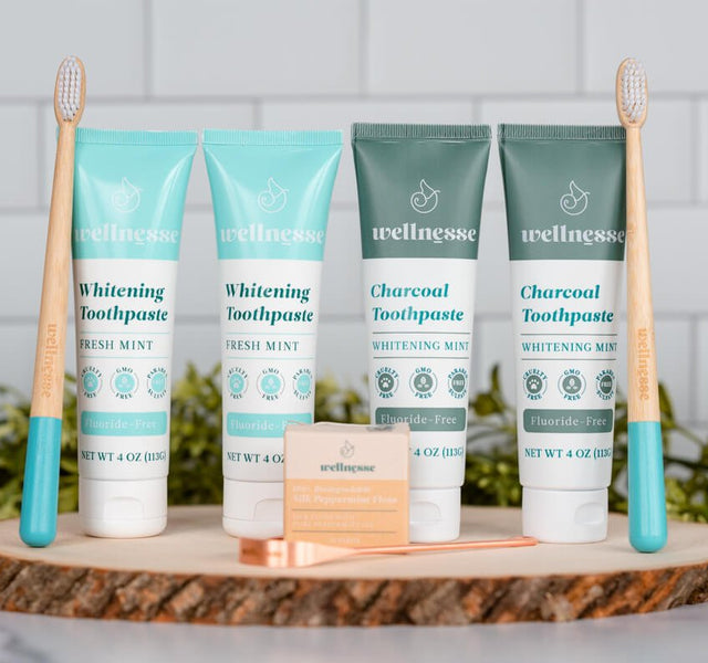 Wellnesse oral care set with whitening toothpaste, silk floss, and bamboo toothbrush on a tray