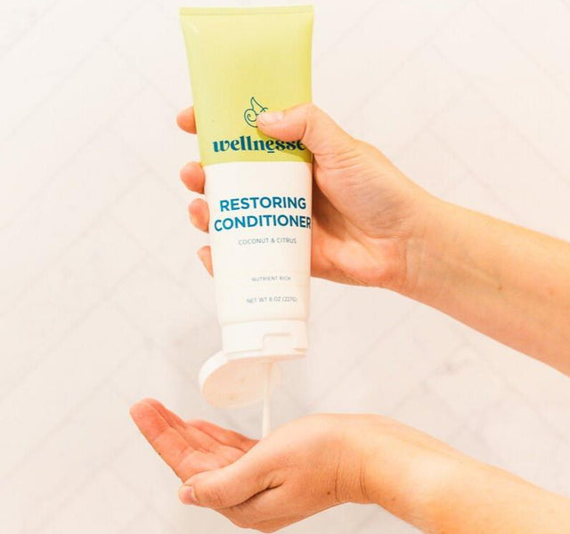 Wellnesse restoring conditioner bottle showing the coconut citrus label and natural formula