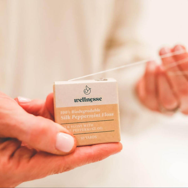 Wellnesse silk floss container showing the compact glass jar design with peppermint-infused thread