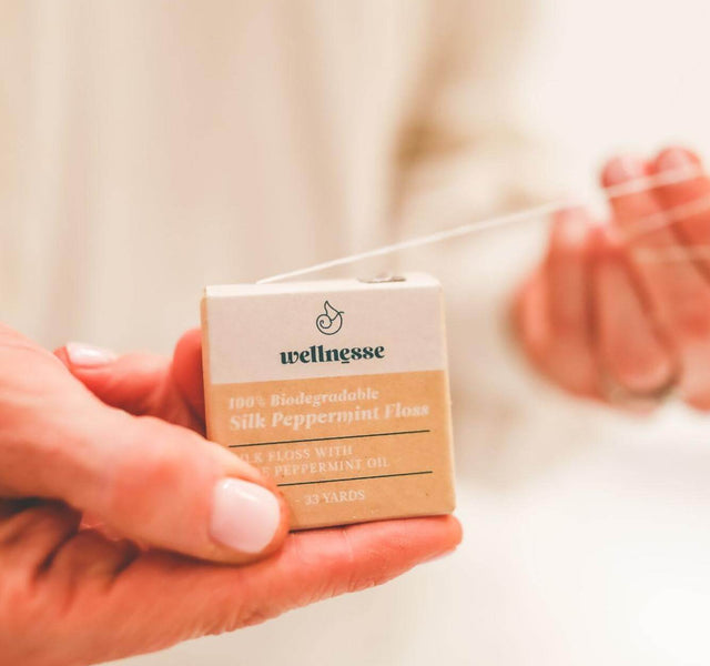 Wellnesse silk floss container showing the compact glass jar design with peppermint-infused thread